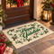Happy Yuletide outdoor rug with green lettering, holly and festive greenery styled outside a traditional front door with Christmas decorations