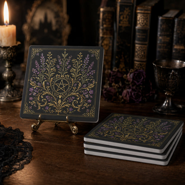 A set of square soapstone coasters with a dark charcoal background and ornate gold filigree, featuring a central pentagram design. One coaster is displayed upright on a small brass stand, while a stack of four coasters rests on the wooden table in the foreground.